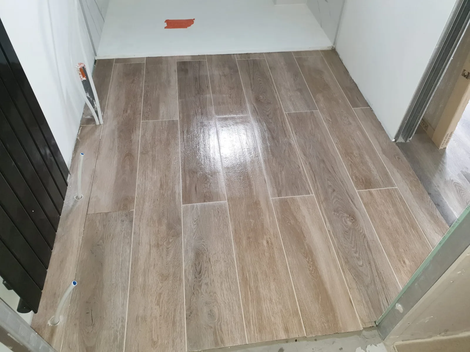 Sol intérieur en carrelage imitation bois posé droit dans une pièce en travaux
