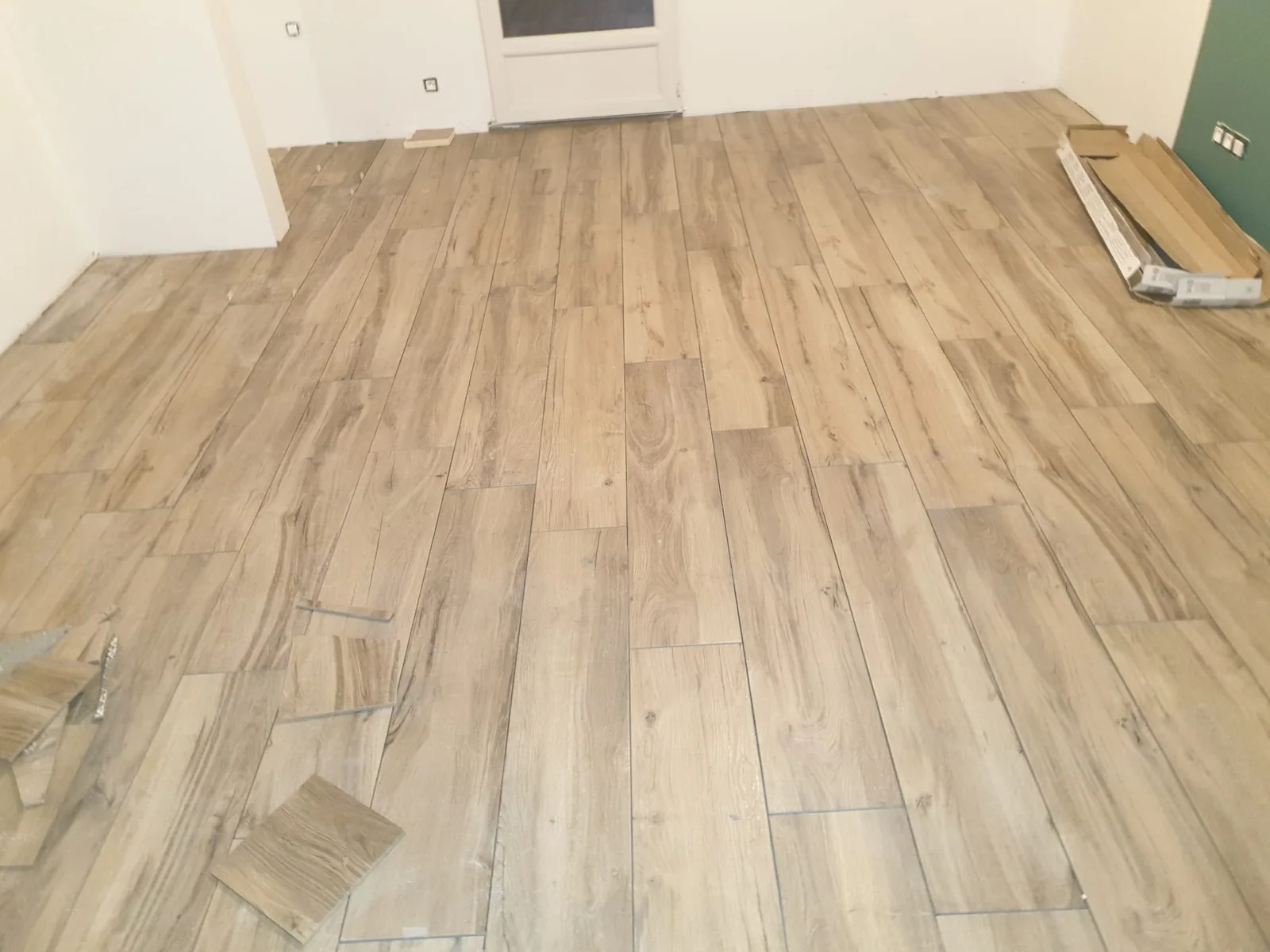 Pièce vide avec sol en carrelage imitation bois chêne clair posé droit à joints décalés